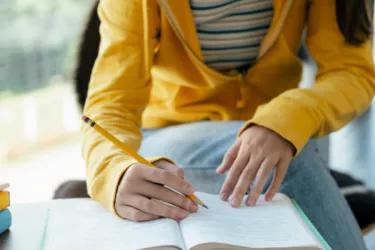A close up of a women writing in a book