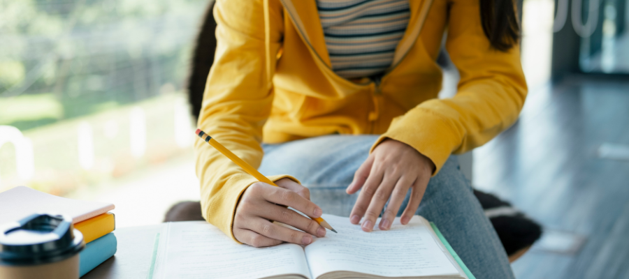 A close up of a women writing in a book